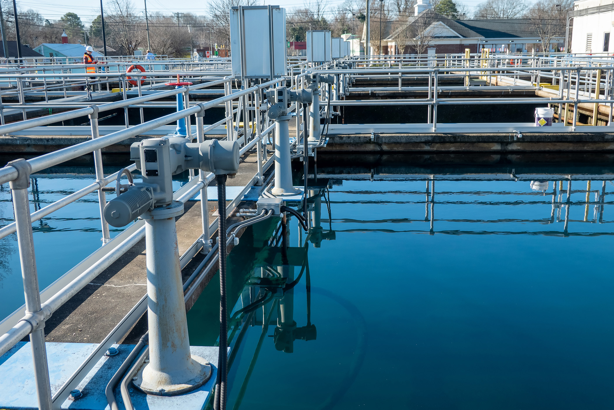 Browne Group - A water treatment facility with clear blue water and metal railings surrounding large tanks.