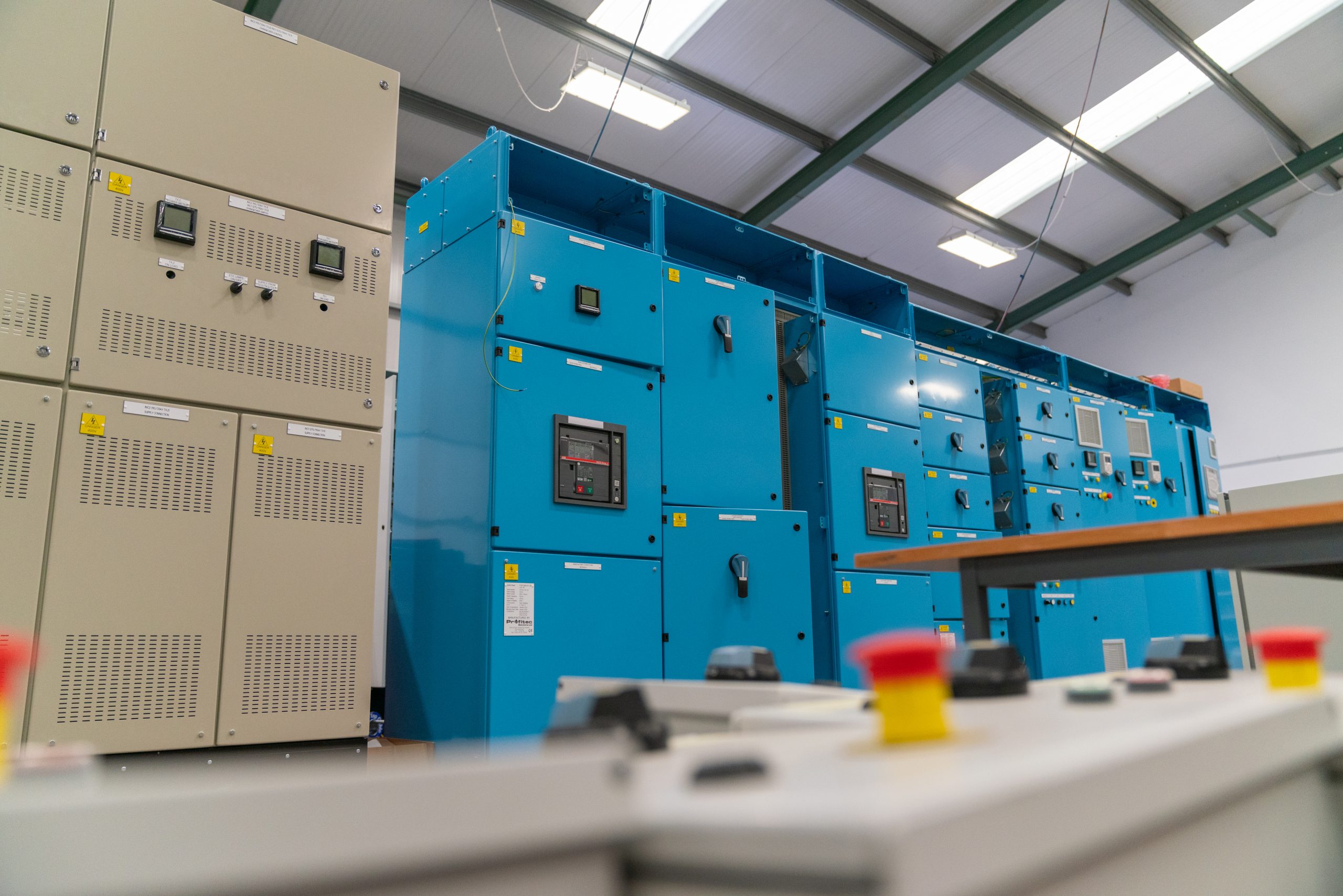 Browne Group - Large blue and beige electrical control panels in an industrial facility, with buttons in the foreground.