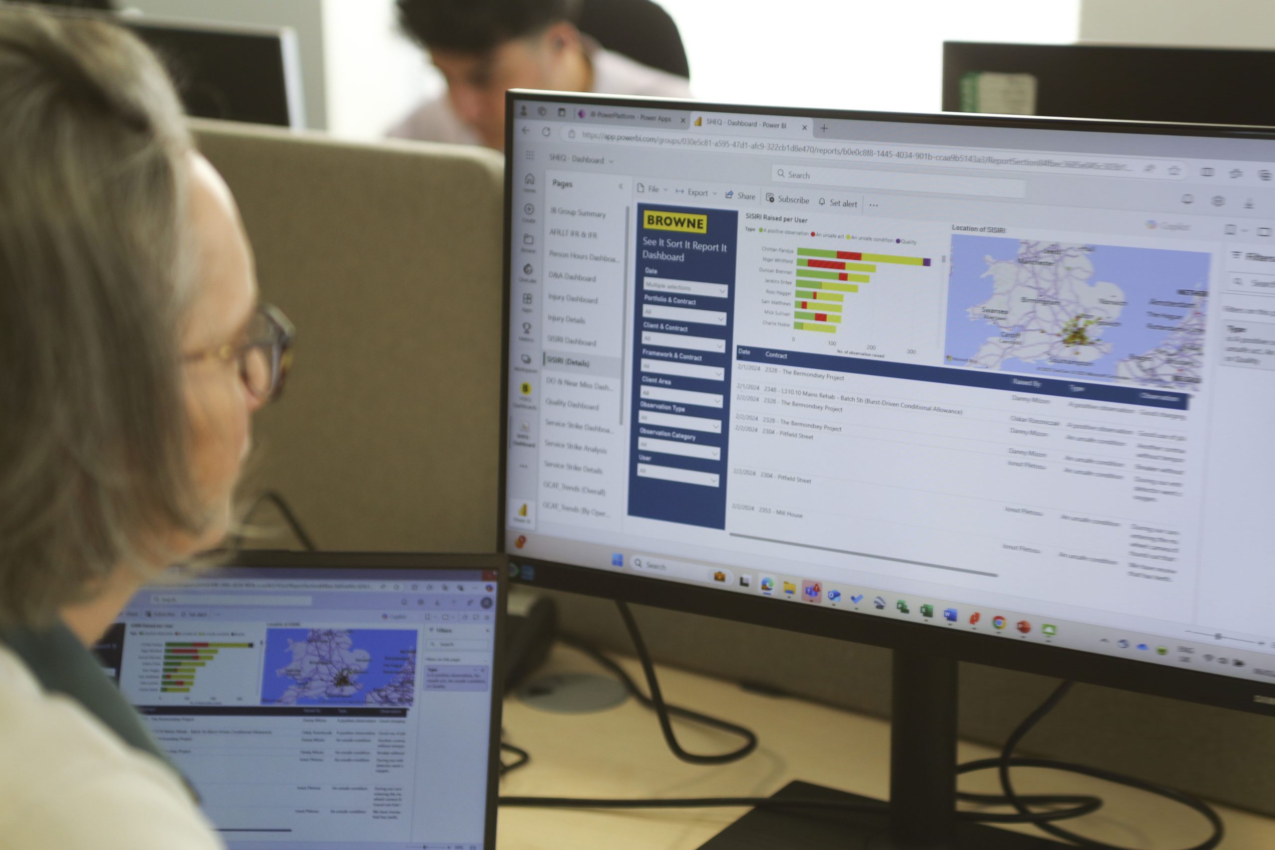 Browne Group - A person looks at data charts and maps displayed on a large computer monitor in an office setting.