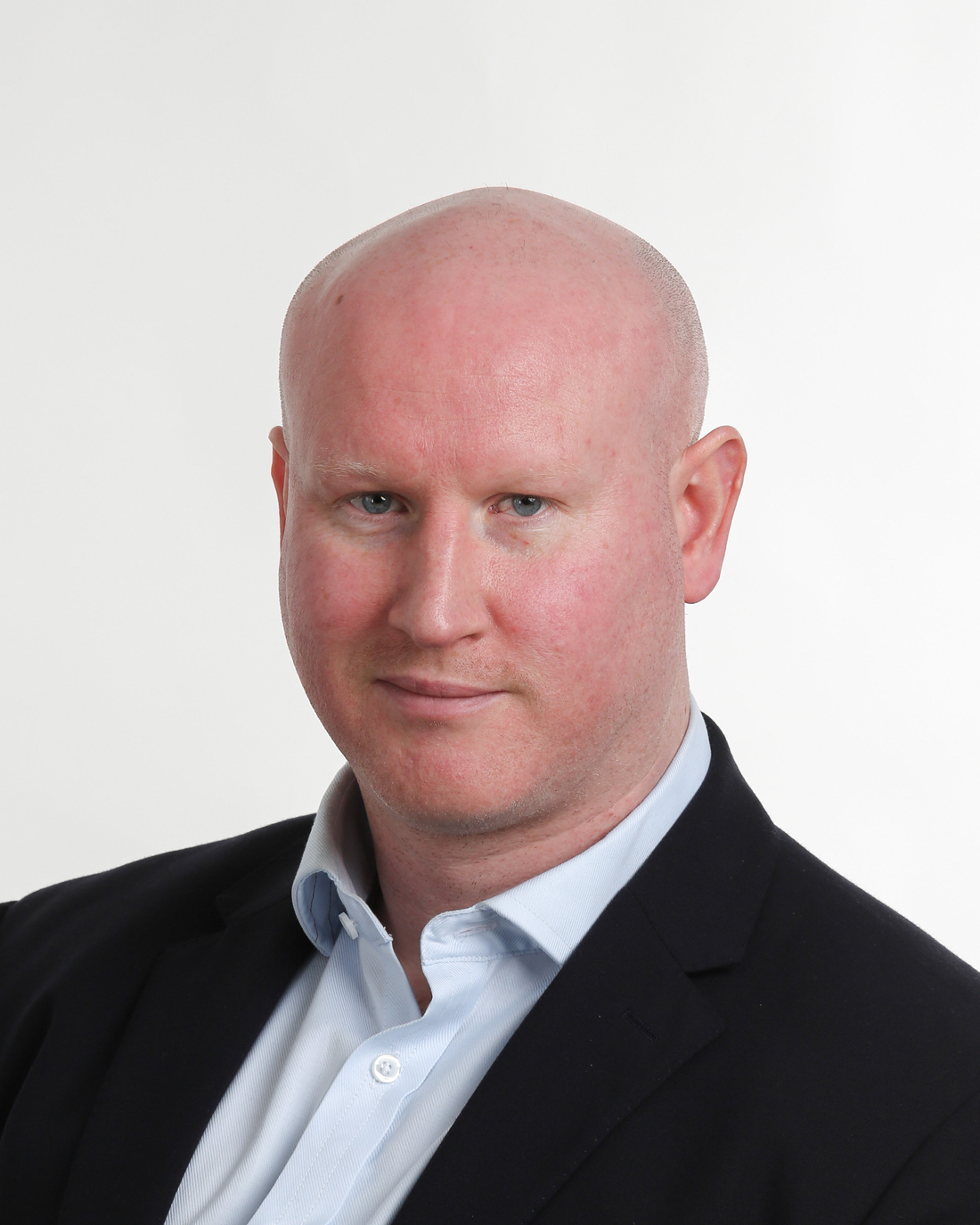 Browne Group - A bald man in a suit jacket and light blue shirt poses against a plain white background.