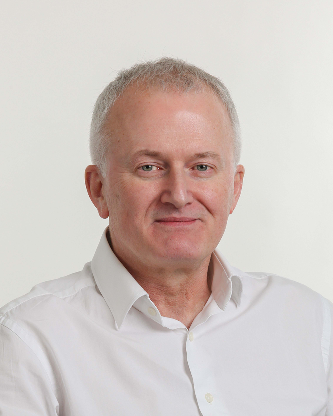 Browne Group - A middle-aged man with short gray hair wearing a white shirt, smiling against a plain background.