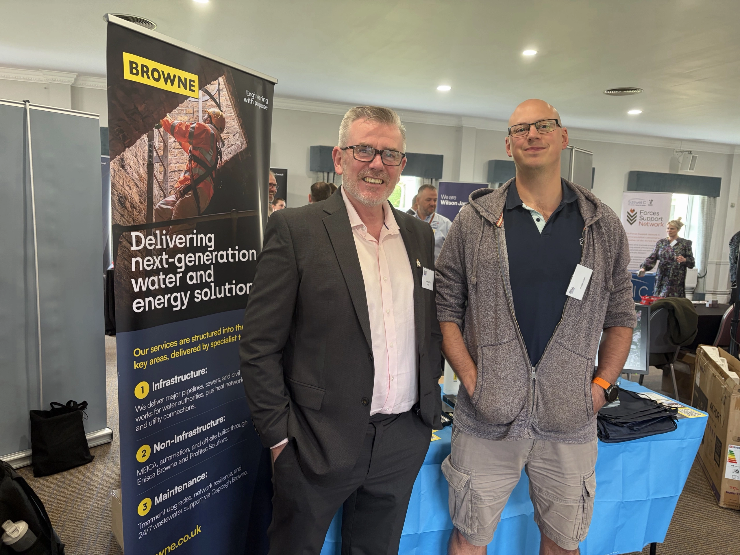 Browne Group - Two men standing in front of a Browne company display banner.